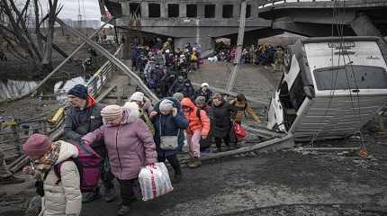 People cross destroyed bridge in Ukraine town 