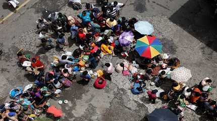 People wait in a queue to buy kerosene at a fuel station