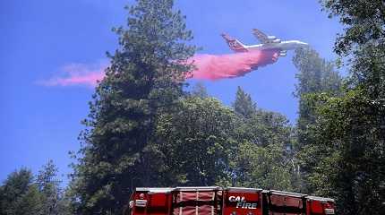 air tanker makes a large retardant drop along a line of the Golden Fire