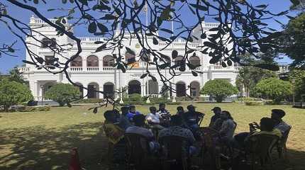 Sri Lankan protesters sit outside the office