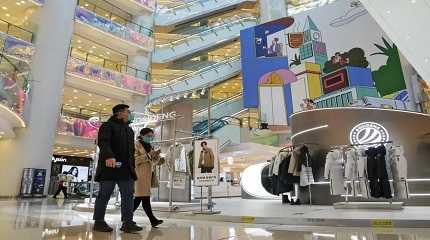 Shoppers walk through a reopened shopping mall