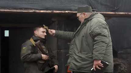 chaplain blesses a soldier to mark Christmas