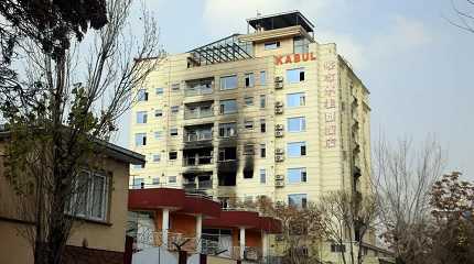 hotel building sits charred after an attack in Kabul