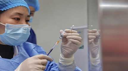 nurse prepares a shot of COVID-19 vaccine