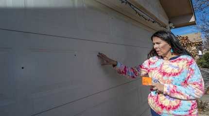 Linda Lopez points to bullet holes