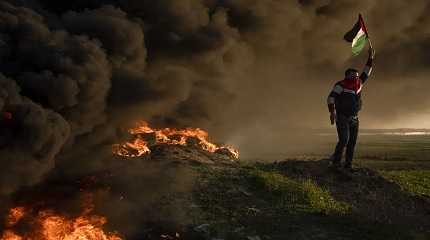 Palestinians burn tires and wave the national flag