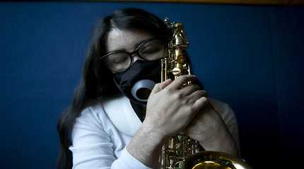 Maria Elena Ríos holds her saxophone