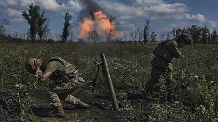 Ukrainian soldiers fire a mortar