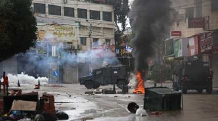 Smoke rises from a burning tire during clashes