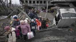 People cross destroyed bridge in Ukraine town