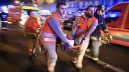 woman is evacuated from the Bataclan concert hall after a shooting