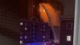 firefighters spray water on a fire at a residential building