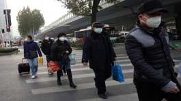 People cross a road amid the coronavirus disease