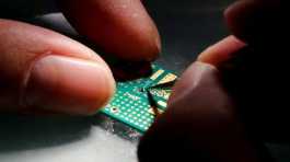 researcher plants a semiconductor on an interface board