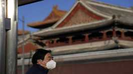 resident wears a mask as he stands near the Lama Temple