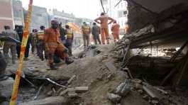 Rescue workers clear the rubble and search for bodies