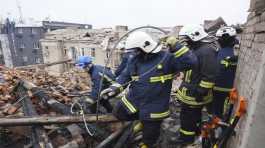 Ukrainian workers clear the rubble