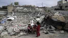 Girls from the Matar family sit near the rubble 