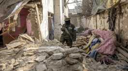 Taliban fighter checks a house
