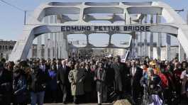 Joe Biden and  John Lewis lead a group across the Edmund Pettus Bridge