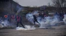 Oil workers run from tear gas