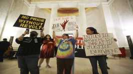 Protestors hold signs