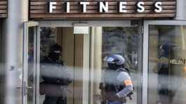 Armed police officers stay in front of a health club