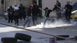 Palestinian demonstrator kicks tear gas