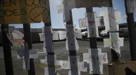 Paper crosses marked with names of migrants who died in last month's fire