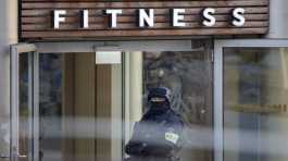 armed police officer stands in front of a health club