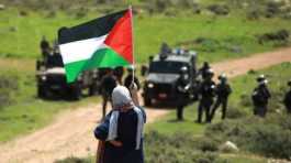 Palestinian woman facing Israeli soldiers