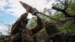 Ukrainian serviceman prepares to fire a mortar 