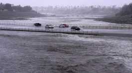 Vehicles cross over a flood