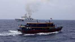 Philippine supply boat sails near a Chinese Coast Guard ship