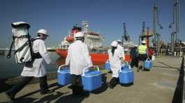 Technical personnel enter a ship loaded with drinking water